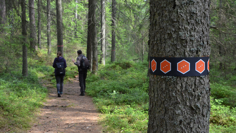 Skogsstig med två människor på