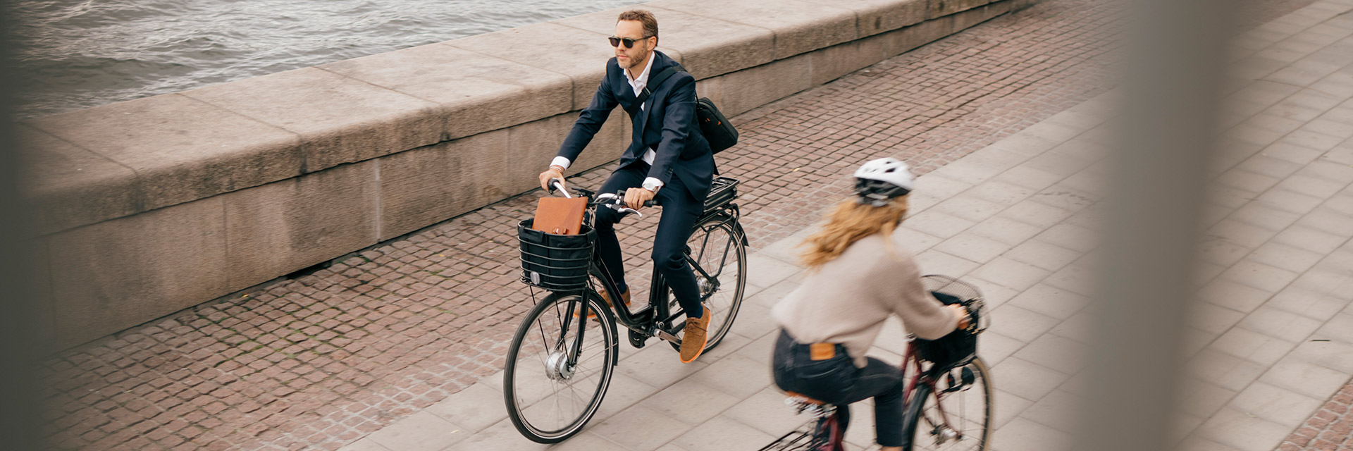 Två personer som cyklar på en strandpromenad